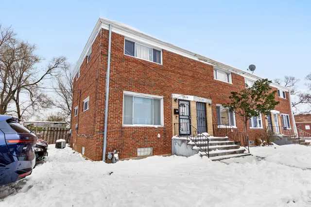 a front view of a house with a yard covered in snow