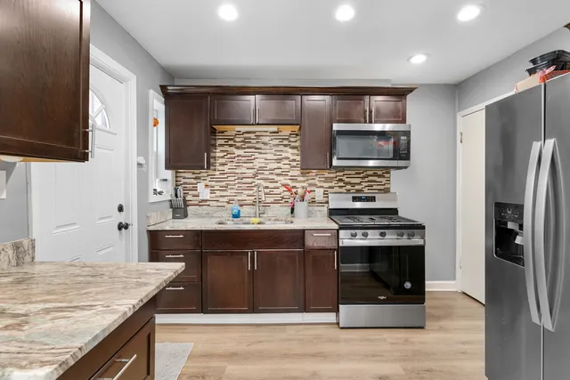 a kitchen with stainless steel appliances granite countertop a stove and a refrigerator