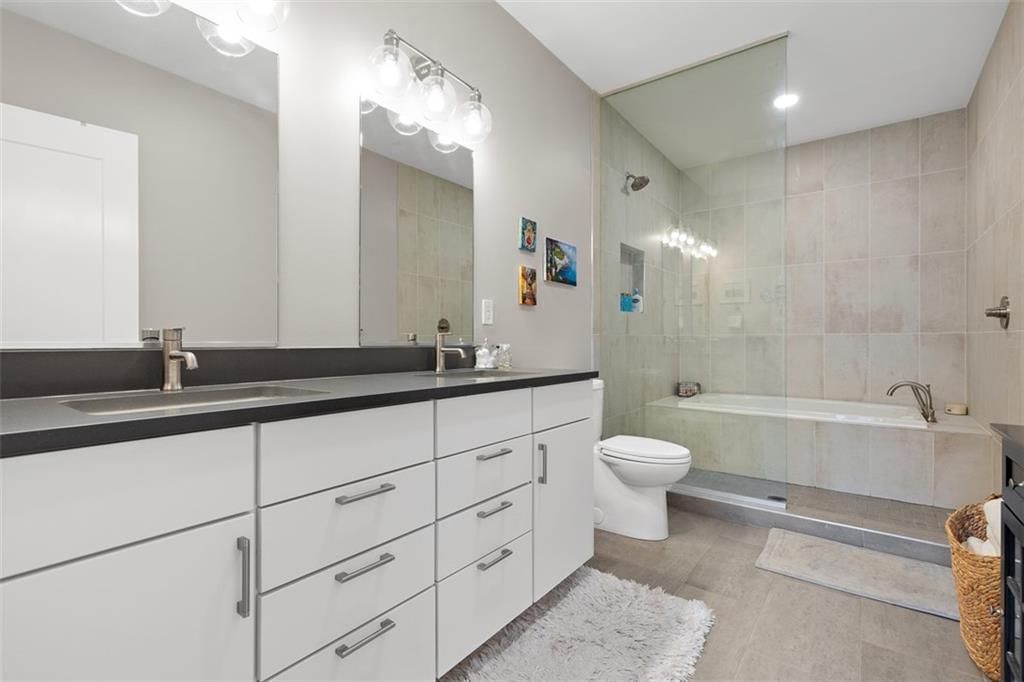 3725 Butler Street, Unit 304 Pittsburgh, PA 15201 - Photo 13 of 26 a bathroom with a double vanity sink toilet mirror and bathtub