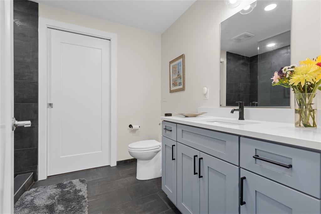 3725 Butler Street, Unit 304 Pittsburgh, PA 15201 - Photo 18 of 26 a bathroom with a toilet sink and mirror
