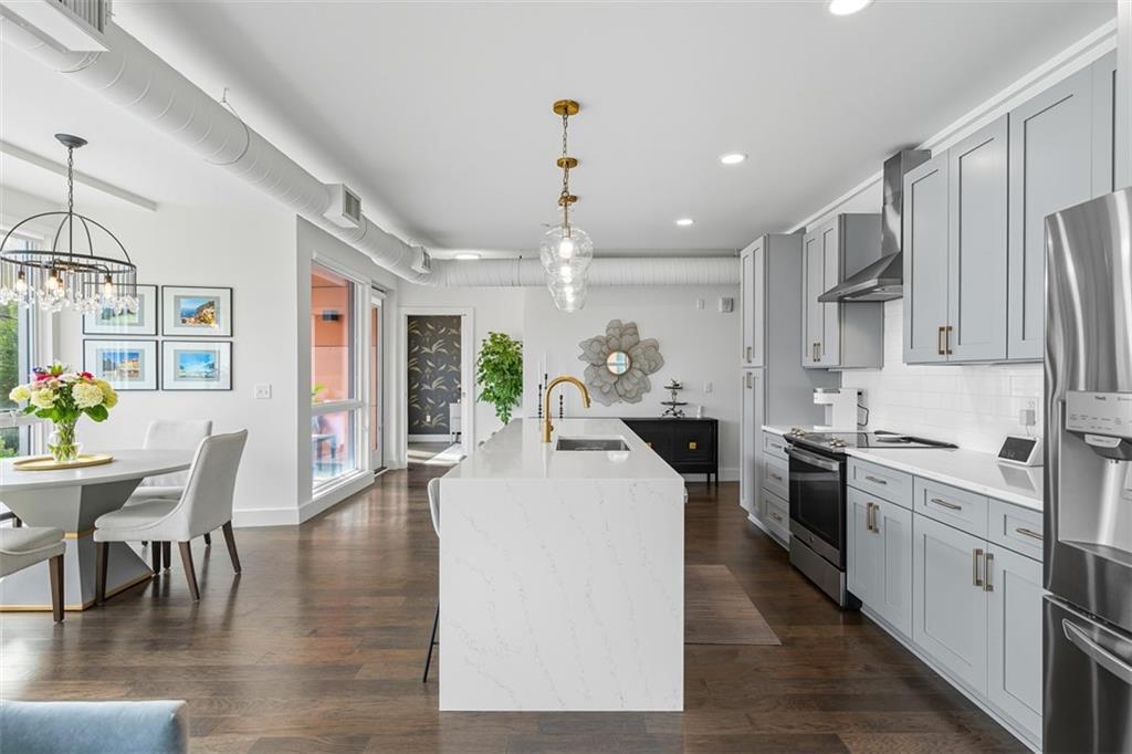 3725 Butler Street, Unit 304 Pittsburgh, PA 15201 - Photo 4 of 26 a large white kitchen with lots of counter space dining table and stainless steel appliances
