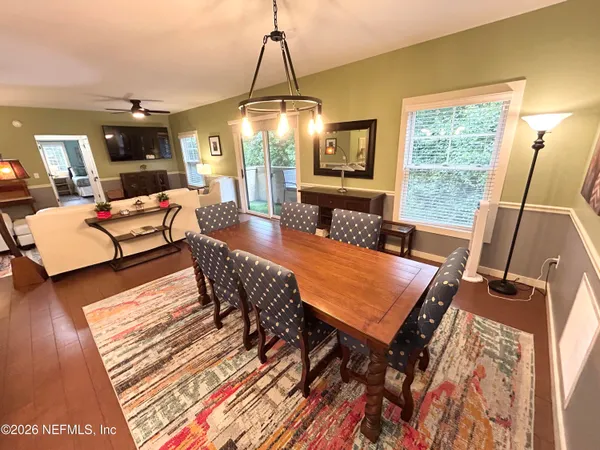 a dining room with furniture a chandelier and wooden floor