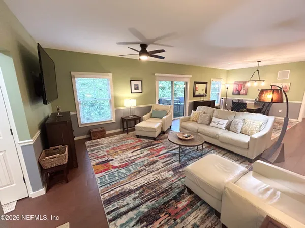 a kitchen with stainless steel appliances a dining table chairs sink and cabinets