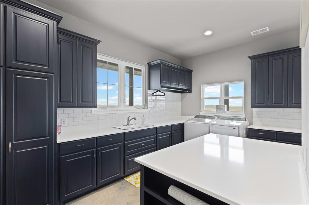 201 W Road Waxahachie, TX 75165 - Photo 21 of 40 a large kitchen with a refrigerator a sink dishwasher a dining table and chairs with wooden cabinets
