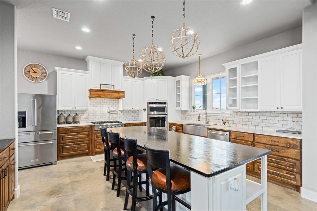 201 W Road Waxahachie, TX 75165 - Photo 4 of 40 a kitchen with kitchen island granite countertop a sink a center island and stainless steel appliances
