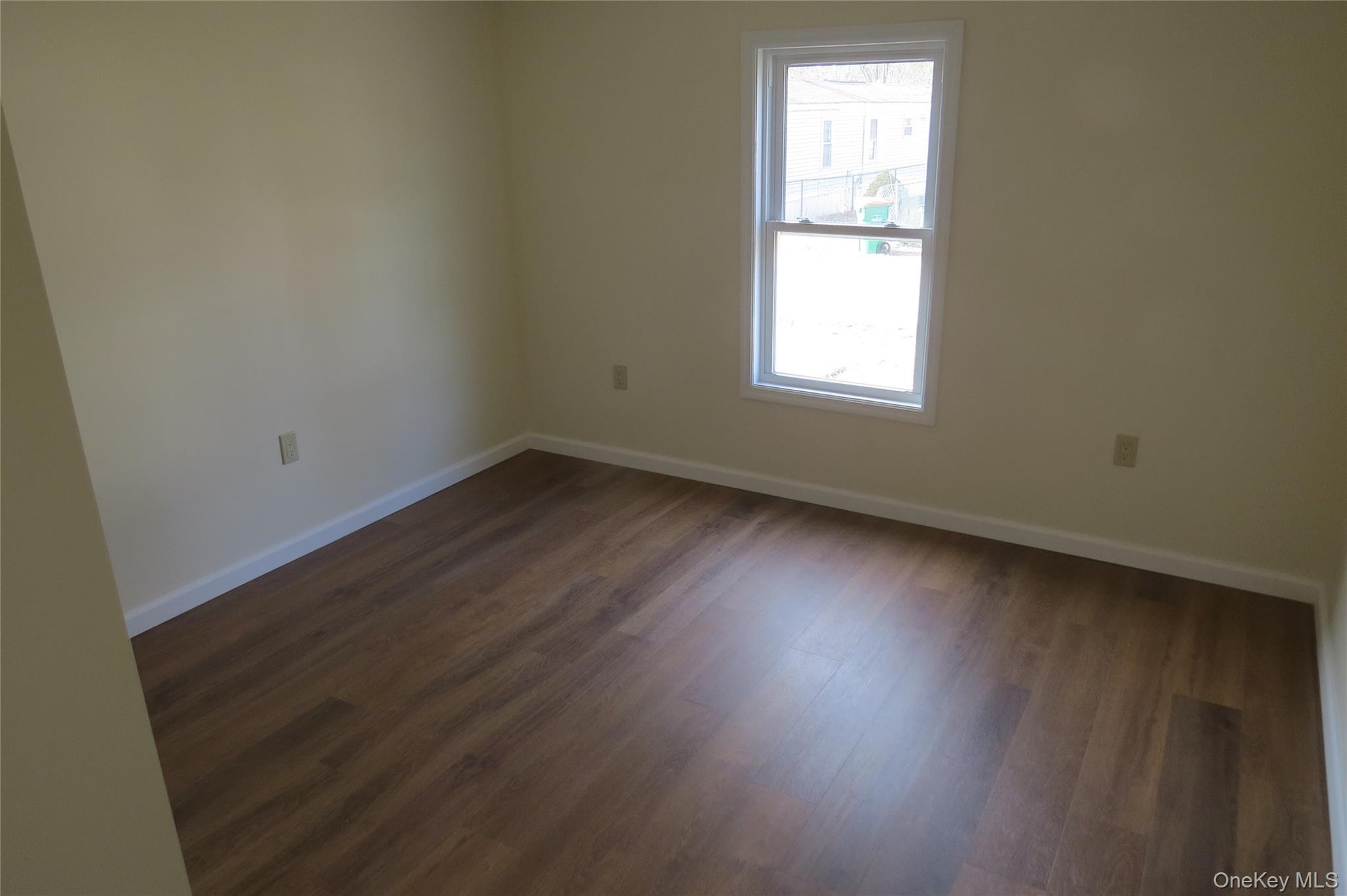 723 Beekman, Unit 64 Hopewell Junction, NY 12524 - Photo 25 of 28 an empty room with wooden floor and windows