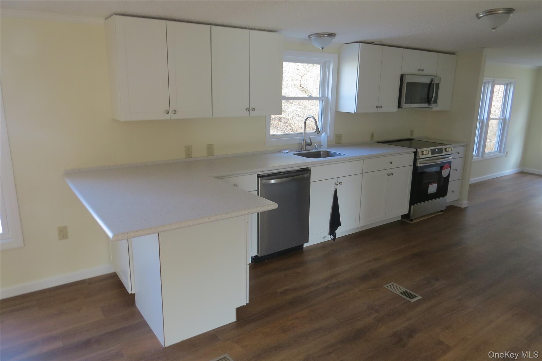 723 Beekman, Unit 64 Hopewell Junction, NY 12524 - Photo 6 of 28 a kitchen with a sink cabinets and wooden floor