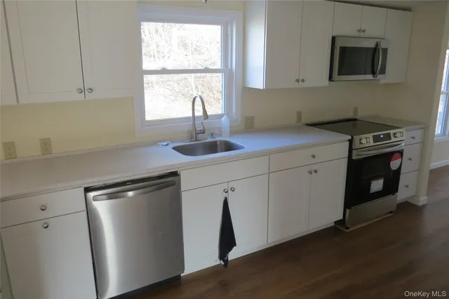 a kitchen with stainless steel appliances granite countertop a sink a stove and a refrigerator