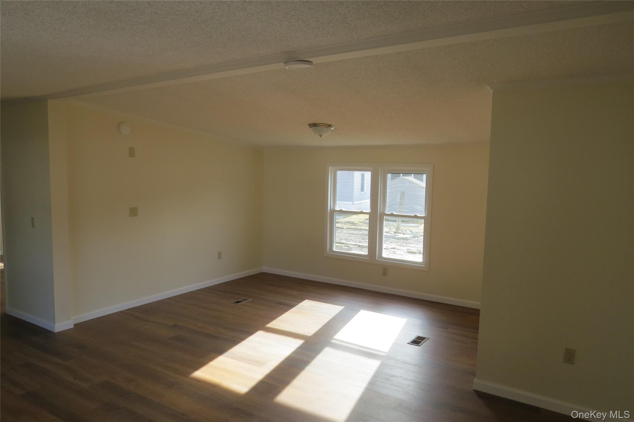 723 Beekman, Unit 64 Hopewell Junction, NY 12524 - Photo 9 of 28 an empty room with wooden floor and windows