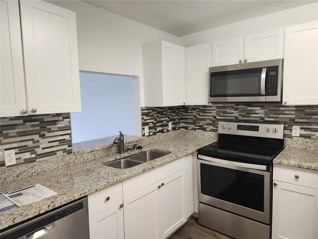a kitchen with granite countertop a stove and a sink