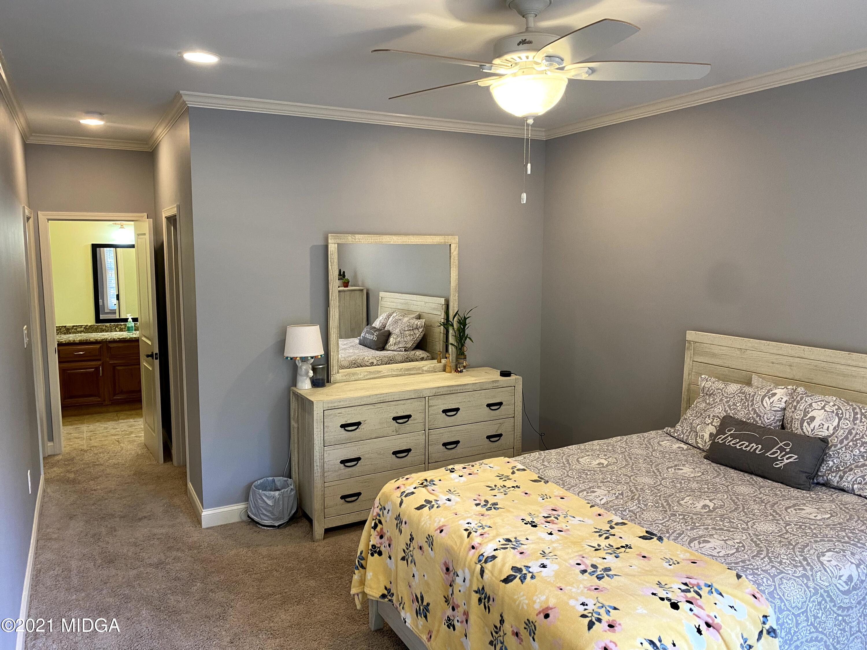 619 Harper Road Perry, GA 31069 - Photo 15 of 27 a bedroom with a bed and a chandelier