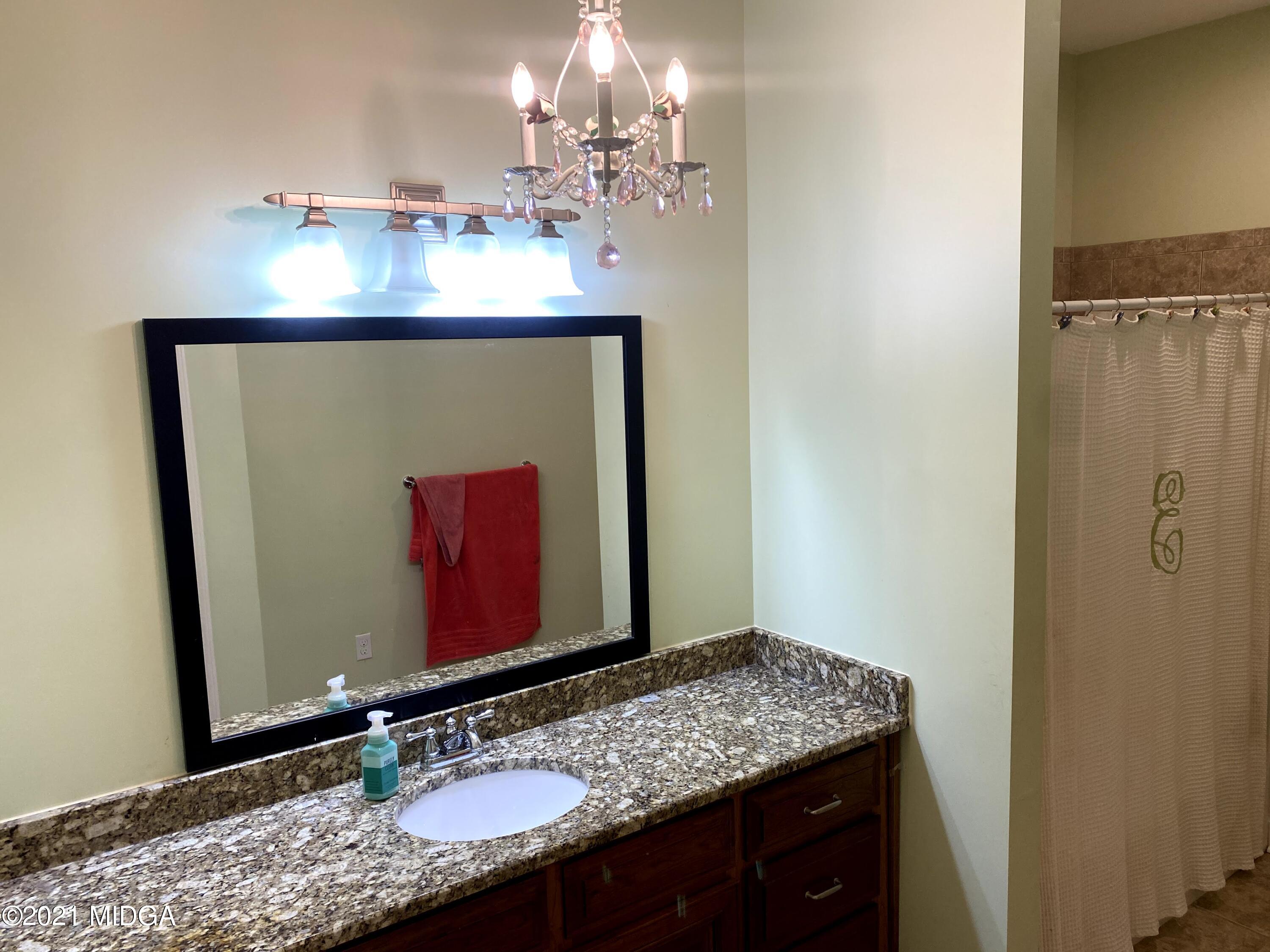 619 Harper Road Perry, GA 31069 - Photo 16 of 27 a bathroom with a granite countertop sink a mirror and a shower