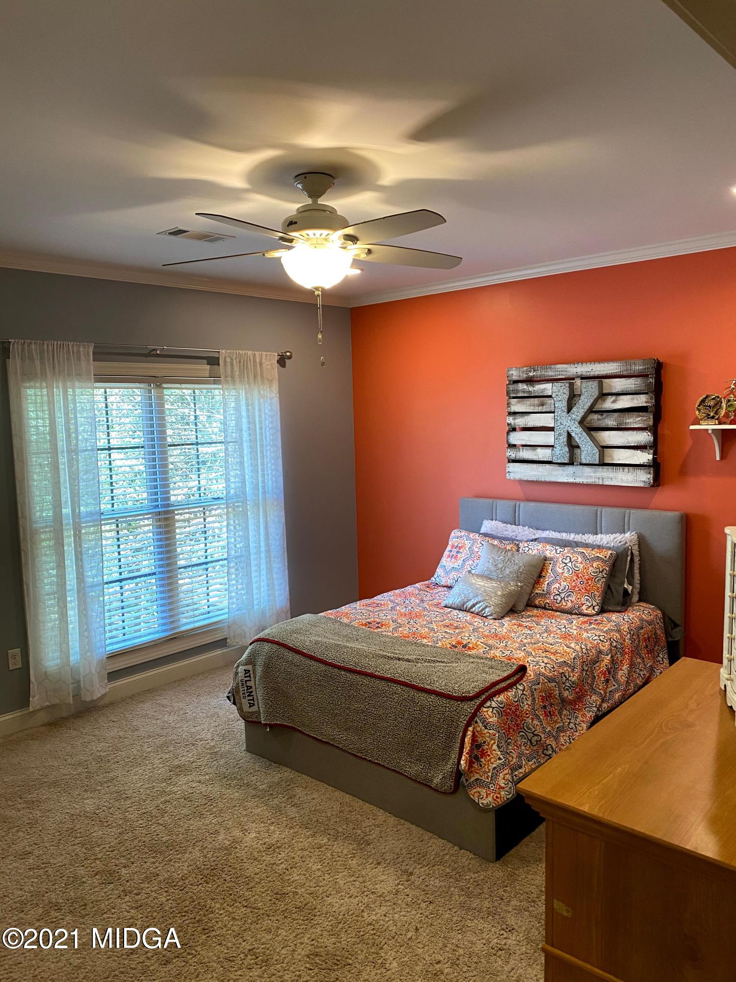 619 Harper Road Perry, GA 31069 - Photo 18 of 27 a bedroom with a bed and a chandelier