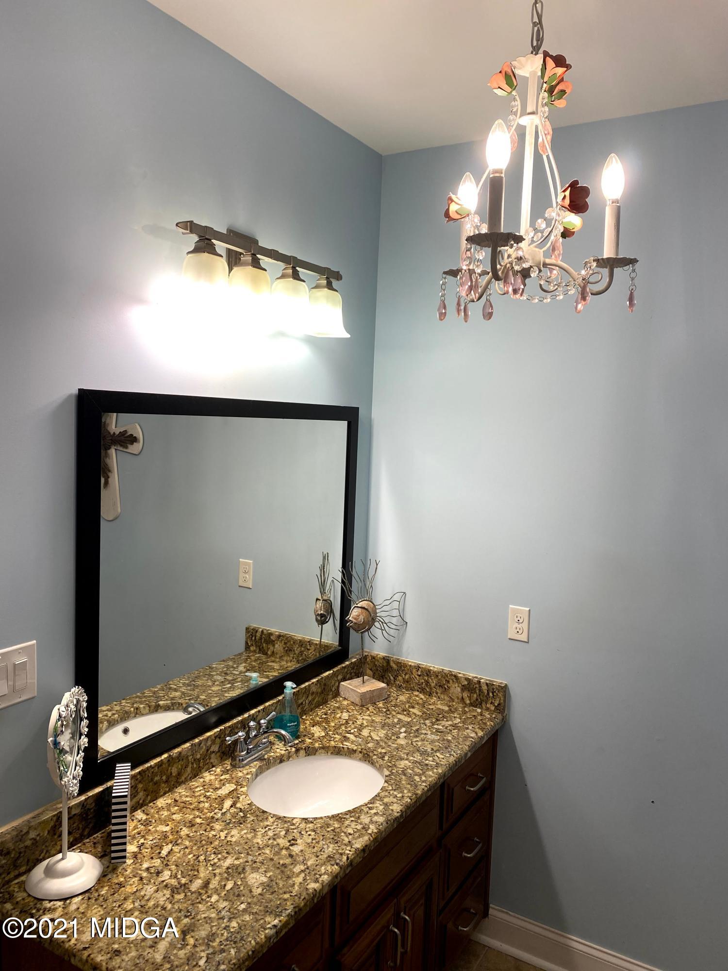 619 Harper Road Perry, GA 31069 - Photo 19 of 27 a bathroom with a granite countertop sink and a mirror