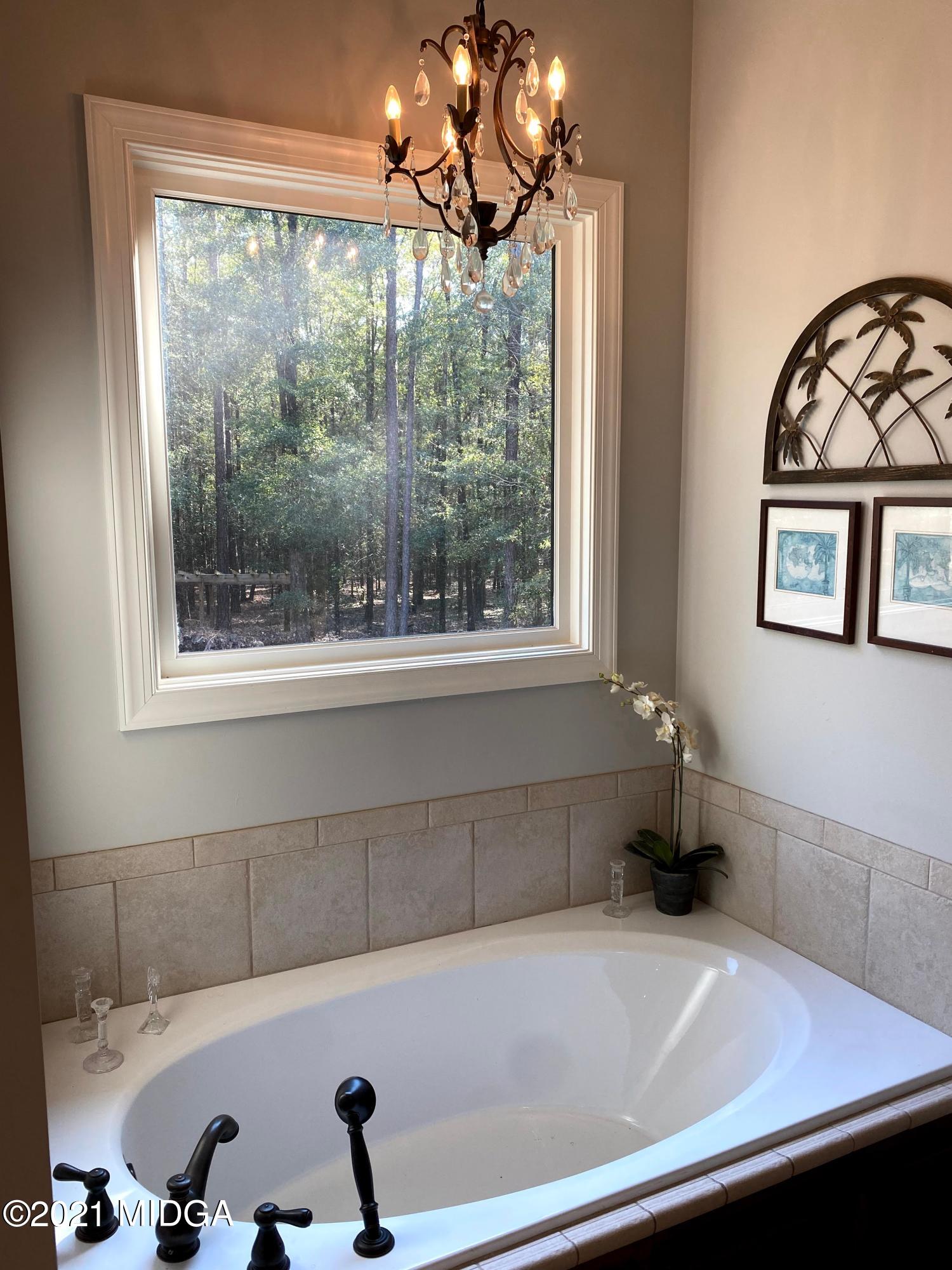 619 Harper Road Perry, GA 31069 - Photo 23 of 27 a bathroom with a bathtub and a window