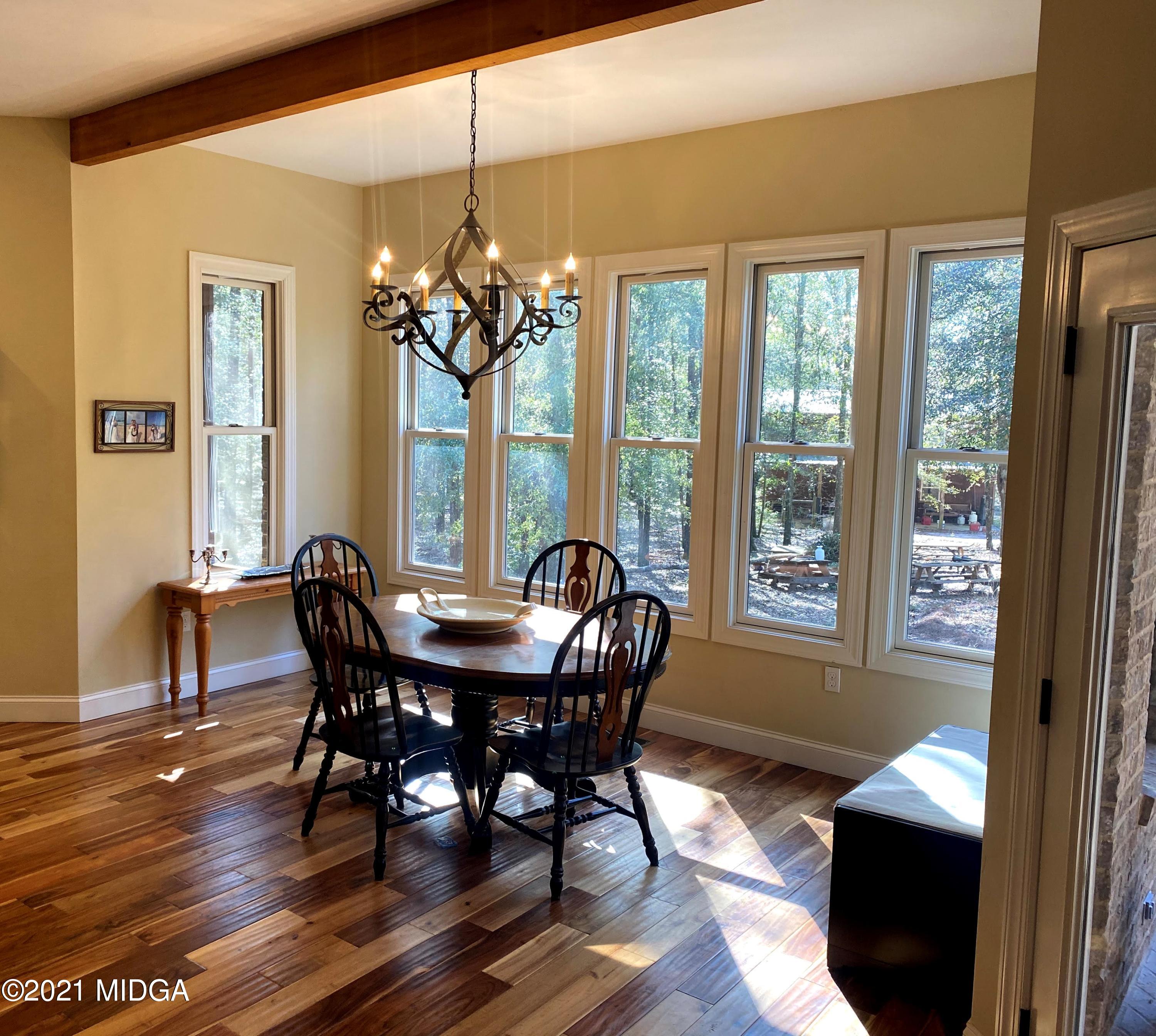 619 Harper Road Perry, GA 31069 - Photo 26 of 27 a view of a dining room with furniture a chandelier and wooden floor