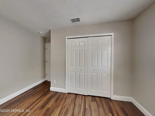 a view of an empty room and wooden floor