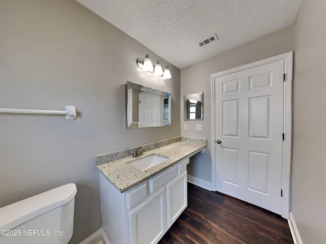 a bathroom with a granite countertop sink and a mirror