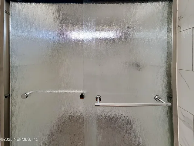 a bathroom with a glass shower door