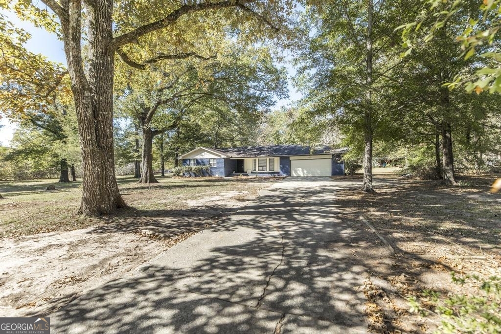 3231 Moody Road Bonaire, GA 31005 - Photo 1 of 1 a backyard of a house with large trees and outdoor seating