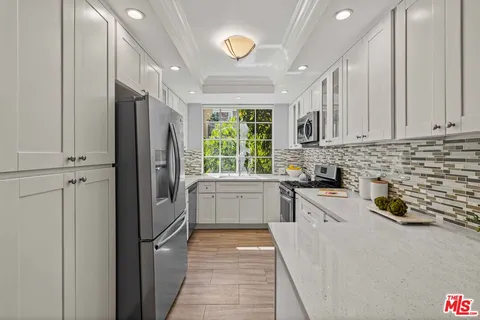 a kitchen with stainless steel appliances a refrigerator sink and cabinets
