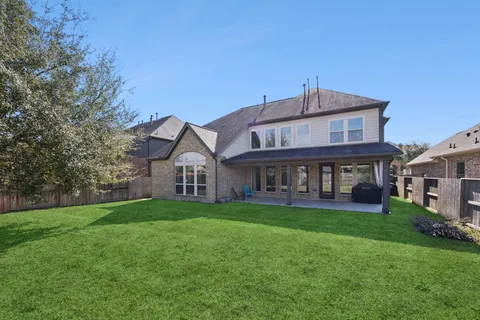 a view of a house with a big yard and large trees