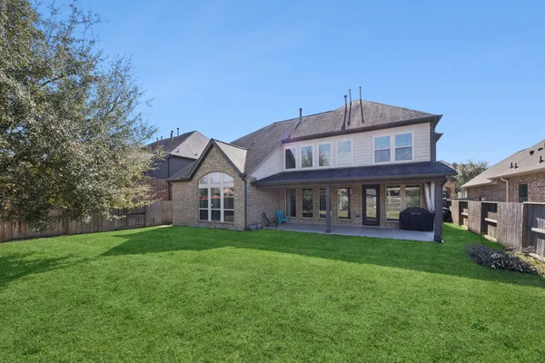 a view of a house with a big yard and large trees