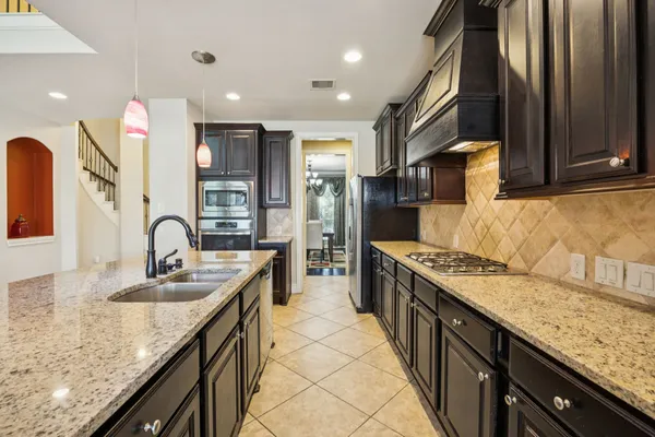 a kitchen with granite countertop a sink stainless steel appliances and cabinets
