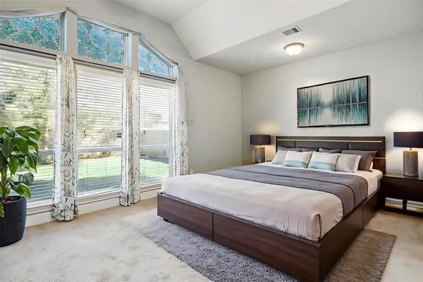 a bedroom with a bed and a large window