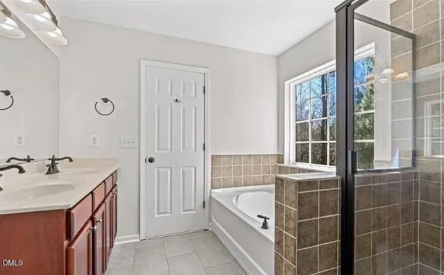 a bathroom with a tub sink shower and mirror