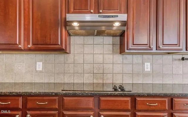 a kitchen with granite countertop cabinets and black appliances
