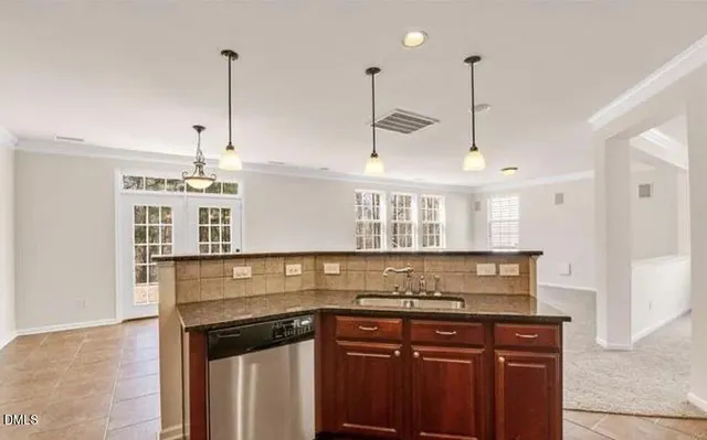 a kitchen with a sink a stove and a wooden floor