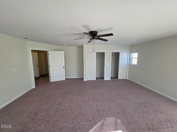 a view of a big room with windows and chandelier fan