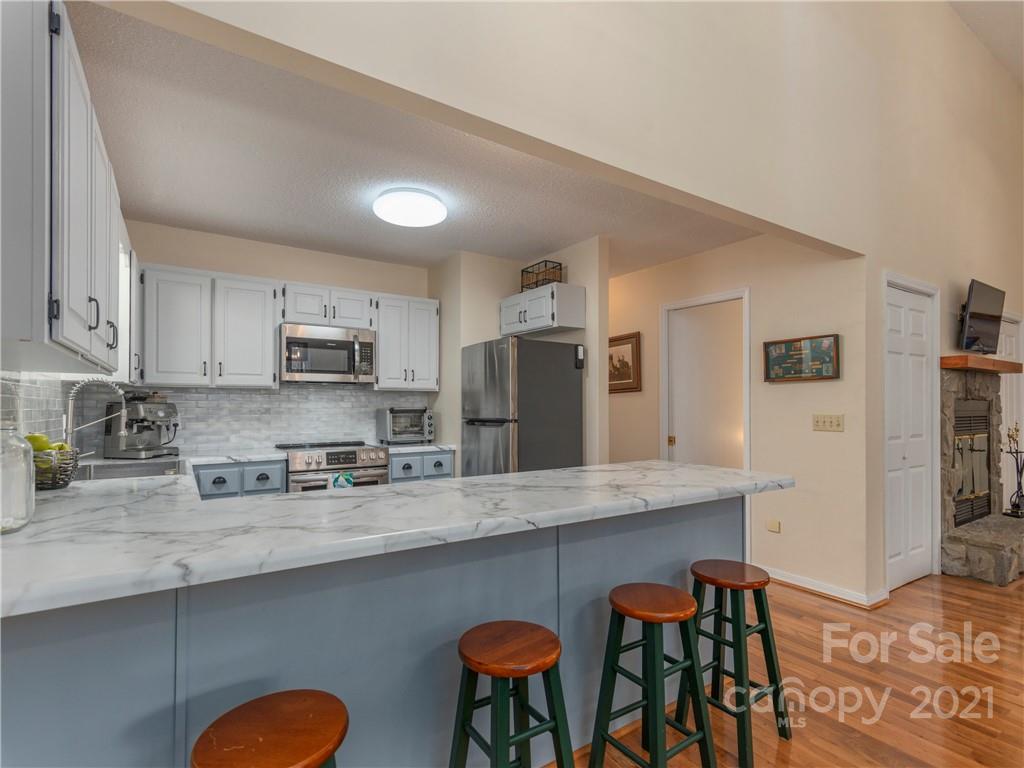 51 Forest Road Canton, NC 28716 - Photo 6 of 26 a kitchen with stainless steel appliances granite countertop a table chairs refrigerator and sink