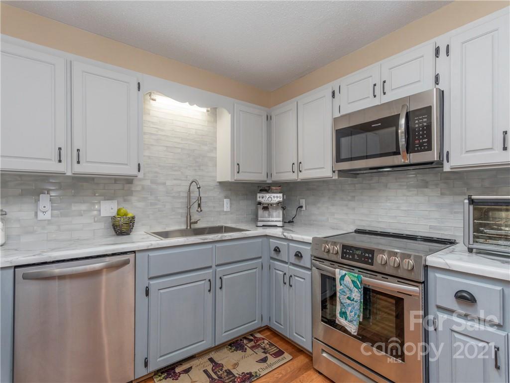 51 Forest Road Canton, NC 28716 - Photo 8 of 26 a kitchen with stainless steel appliances granite countertop a sink a stove a microwave and cabinets