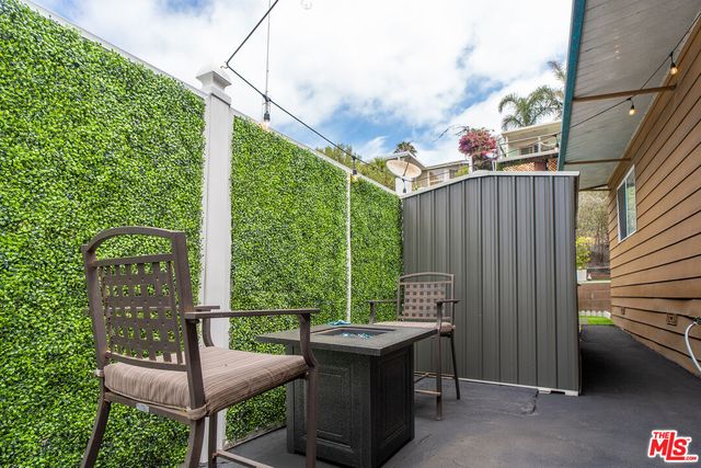 a view of a patio with table and chairs and wooden fence