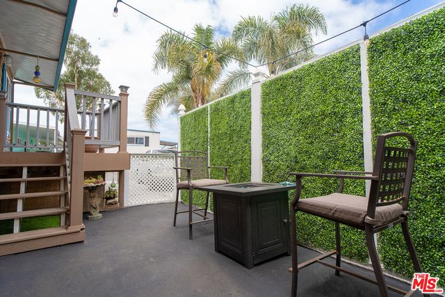 a view of a chairs and table in the back yard of the house