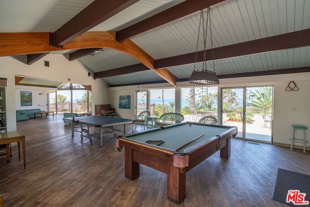 a room with furniture pool table wooden floor and view