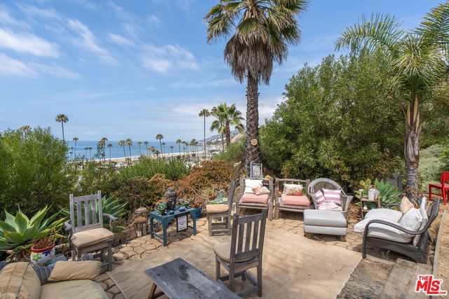 a backyard of a house with table and chairs