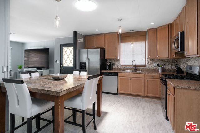 a kitchen with a table chairs refrigerator and microwave