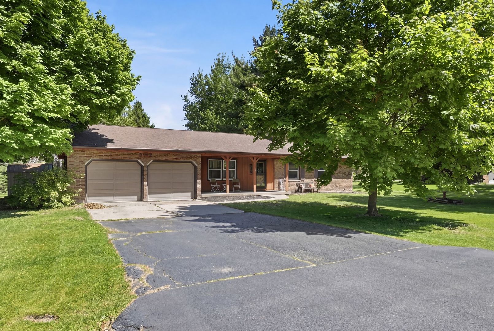5645 Beebe Drive Rochelle, IL 61068 - Photo 5 of 43 a front view of a house with a garden and trees
