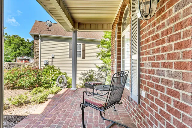 a view of a porch with chairs and potted plants