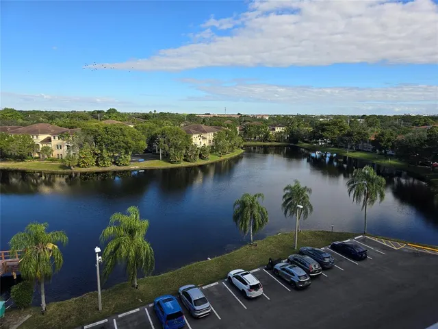 an aerial view of a city with lots of residential buildings ocean and mountain view in back