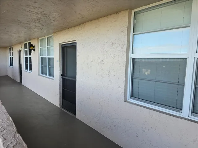 a view of hallway with a refrigerator and window