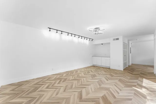 a view of a livingroom with wooden floor and entryway