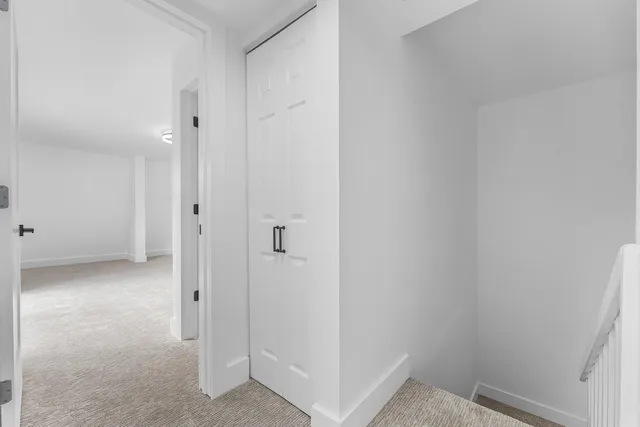 an empty room with a fan & a window