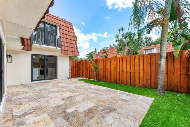a view of a swimming pool with a yard and plants