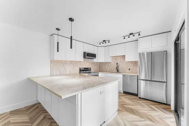 a kitchen that has a cabinets a sink and a refrigerator