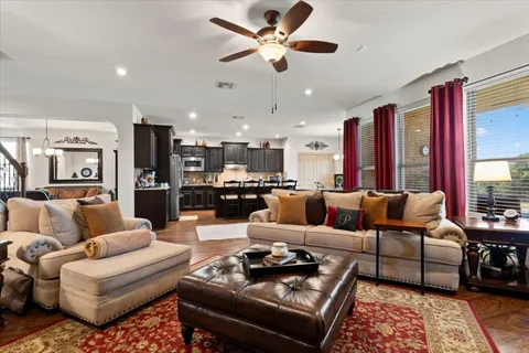 a living room with furniture ceiling fan and a rug