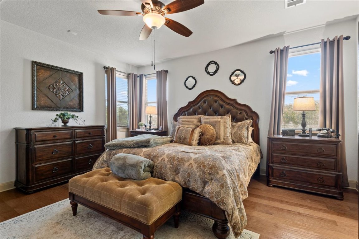 224 Whitney Woods Circle Georgetown, TX 78633 - Photo 18 of 40 a bedroom with a bed and a chandelier